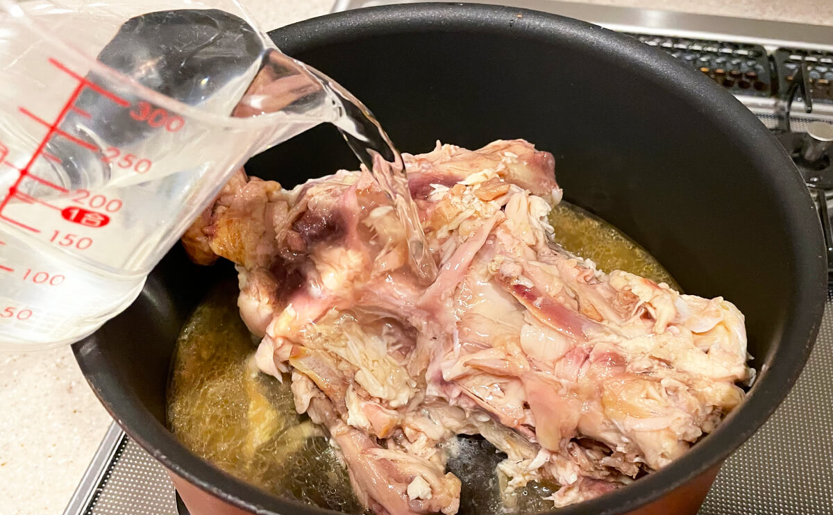 解体して身を取り外したロティサリーチキンの鶏ガラと水を鍋に入れます